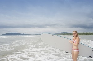 Young woman with surfboard on beach